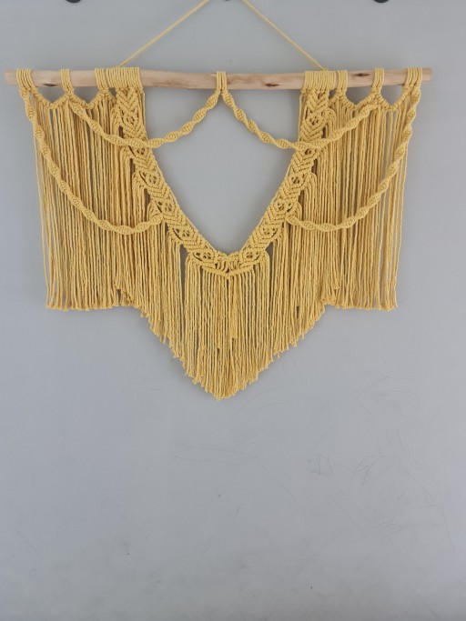 Padrões de macramê detalhados que criam uma peça de arte única para a sua parede, cor vibrante com tom amarelo ensolarado traz, confeccionado com fios de algodão, proporcionando uma textura suave 